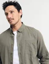 Camisa color ladrillo de lino y algodón, con cuello abotonado, manga 3/4 con puños arremangados, corte clásico y bolsillo de parche en el pecho.