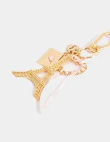 Llavero dorado con dije de la Torre Eiffel, sobre dorado con corazón rosa, dije redondo con la palabra "Love" y cinta de raso rosa.