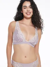 Conjunto de ropa interior lila con detalles de encaje blanco, compuesto por un bralette triangular con breteles regulables y una bombacha tipo tanga.