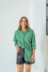 Camisa color beige de corte clásico, con cuello camisero, mangas largas con puños abotonados y cierre frontal con botones.