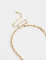 Collar corto dorado con doble cadena, una con dijes de estrellas y otra con dijes de corazón dorado y piedra rosa.