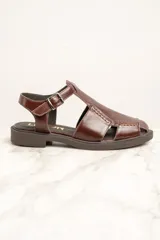 Sandalias de cuero marrón con diseño de tiras cruzadas y hebilla lateral.