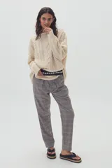 Pantalón de vestir con estampado a cuadros en tonos grises y negros.