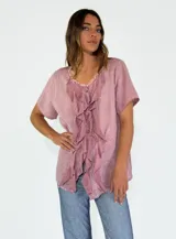 Camisa de lino y algodón color rosa claro, con cuello en V, mangas cortas y volados frontales.