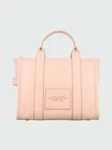 Bolso tote de cuero negro Marc Jacobs, tamaño mediano, con doble asa corta y correa larga extraíble. Estampado frontal con el texto "THE TOTE BAG" y el nombre de la marca.
