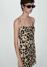Vestido corto con tirantes finos y estampado animal print en tonos beige y negro.