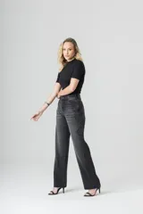 Pantalón de jean negro de tiro alto, corte recto y diseño de piedras en el lateral de las piernas.