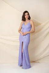 Vestido largo de fiesta color lila con lentejuelas, breteles finos cruzados en la espalda y tajo alto en la pierna.