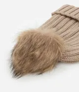 Gorro de lana color blanco con textura acanalada y pompón de pelo sintético en la parte superior.