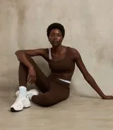 Top deportivo marrón de microfibra con breteles asimétricos y superficie acanalada.