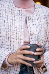 Chaqueta corta tipo Chanel de tweed color rosa, con botones fantasía y cuello redondo.