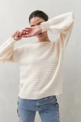 Sweater negro tramado de silueta relajada, con combinación de texturas en el tejido y mangas abullonadas con puños elastizados.