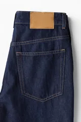 Jean de tiro alto con piernas anchas y rectas, de denim azul oscuro.