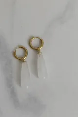 Par de aros dorados con cierre de gancho y dije colgante en forma de gota de piedra natural blanca.