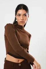 Polera tejida color marrón chocolate, de manga larga y cuello alto con abertura en el pecho.