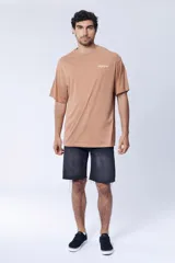 Remera color camel, corte oversize, con cuello redondo y estampado pequeño con la palabra 'Dragon' en el pecho.