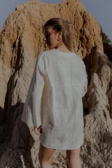 Camisa blanca de broderie con escote en V y mangas largas.