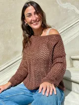Sweater de tejido de punto calado color marrón con lurex en cuello, puños y ruedo. El cuello puede usarse mostrando un hombro o de forma tradicional.