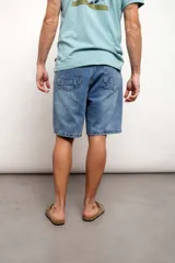Bermuda de jean negra con roturas y largo a la rodilla.