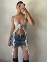 Top plateado con lentejuelas, breteles finos y lazo ajustable en el frente.