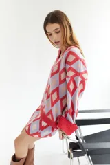 Sweater oversize con cuello en V y estampado de rombos en tonos lila, rosa y rojo. Tejido de lana artesanal.