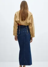 Falda midi de denim azul oscuro, corte recto, tiro alto, con bolsillos delanteros y traseros, trabillas para cinturón, cierre con cremallera y botón, y abertura frontal.
