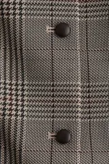 Chaleco entallado con estampado a cuadros, cuello redondo y cierre frontal con botones.