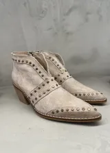 Bota corta de cuero color beige con tachas metálicas, cierre lateral y taco de madera.