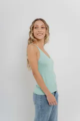 Musculosa amarilla de hilo con brillo sutil, de calce ajustado y breteles finos.