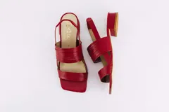 Sandalias rojas de cuero con taco bajo y tiras finas en el empeine y tobillo.