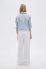 Pantalón de lino color beige, de corte recto y tiro alto, con bolsillos laterales.