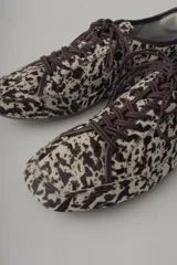 Championes de cuero con estampado animal print en tonos marrones y beige.
