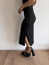 Conjunto negro de bambula elastizada, compuesto por un top off-shoulder y una falda midi ajustada con abertura lateral.