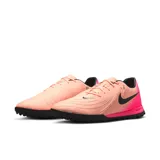 Championes de fútbol Nike Phantom Gx Ii Academy Tf, color salmón con detalles en fucsia y logo en negro.