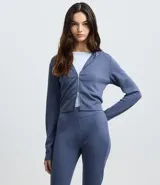 Campera corta de modal color azul, con capucha fija, mangas largas y cierre frontal de cremallera.