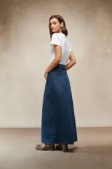 Falda larga de mezclilla color marrón chocolate, de tiro alto con cordón ajustable en la cintura y abertura frontal pronunciada.