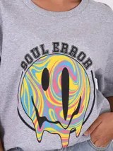 Remera gris de corte oversized con estampado gráfico en el frente, de manga corta.