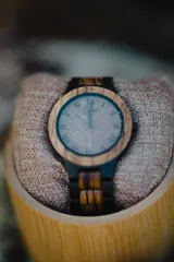 Reloj de pulsera para hombre, con caja y correa de madera clara. Esfera con números romanos grabados con láser y manecillas negras.