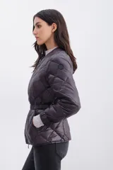 Campera de nylon color berenjena con relleno de pluma, corte regular, cierre doble en delantero y bolsillos. Cinturón elástico gofrado en la espalda y mangas largas con elástico en puños.