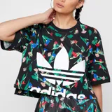 Remera Adidas negra con estampado floral multicolor, logo de Adidas estampado en el frente y corte crop.