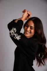 Camisa celeste de corte clásico, con botones frontales y bordados florales en las mangas.