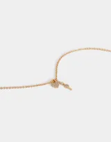 Cadena corta dorada con dije de candado en forma de corazón y llave, ambos con incrustaciones de strass.
