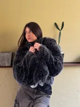 Campera corta de piel sintética color gris oscuro con mangas largas y cuello redondo.