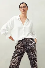 Camisa blanca de manga larga con textura arrugada (tipo 'burbuja' o 'crepe'), cuello clásico y puños fruncidos con elástico.