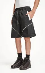 Bermuda negra con recortes blancos, calce oversize de textil liviano, con elástico en la cintura y cordón de ajuste con bolsillos delanteros y traseros.