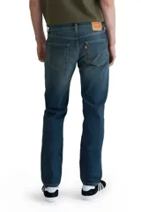 Jeans de corte slim fit, color azul oscuro con desgaste en muslos y rodillas.