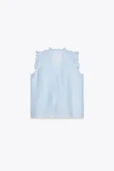 Blusa celeste sin mangas con escote en V y volantes.