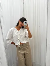 Blusa color blanco de lino, con mangas 3/4 y volados en el frente. Se ata con lazos en el centro.