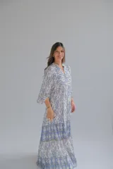 Vestido largo celeste y blanco con estampado geométrico, escote en V y mangas 3/4.