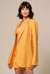 Blazer color mostaza con textura de lunares, solapas clásicas y forro interno.